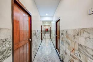 Un pasillo con puerta de madera y paredes de piedra. en Super Hotel O M.G. Road, Ranigunj, Secunderabad, en Hyderabad