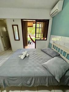 Un dormitorio con una cama grande con un animal de peluche encima. en Pousada Charle Brown, en Garopaba