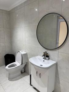 a bathroom with a toilet and a sink and a mirror at Luu Luxury Suite in East London