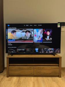 a flat screen tv sitting on top of a wooden stand at Oak Room Ở Space Ecopark in Kim Quan +1 photo