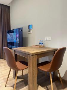 a wooden table with two chairs in a room at Oak Room Ở Space Ecopark in Kim Quan
