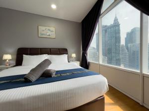 a bedroom with a large bed with a large window at Vortex Suites KLCC By GuestHouse in Kuala Lumpur +35 photos