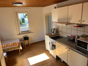 a kitchen with white appliances and a table and a window at Siegen Achenbach 2 in Siegen