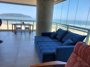 a blue couch in a living room with a view of the beach at Book Santos - Unlimited 901 - Frente Mar com Vista Panorâmica in Santos +47 photos