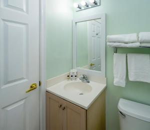 ein Badezimmer mit Waschbecken und Spiegel in der Unterkunft Drifting Sands Oceanfront Hotel in Ship Bottom