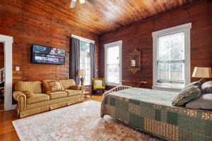 a bedroom with a bed and a couch and a tv at The Bowie Grand - Historic Comfort in Seguin in Seguin