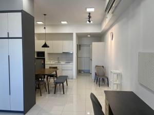 クアラルンプールにあるChambers Residence KL By Blue Door Suiteのテーブルと椅子のあるキッチンとダイニングルーム