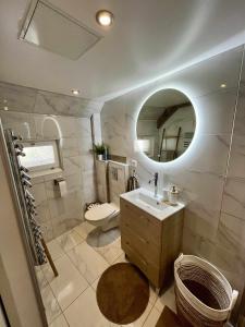 a bathroom with a sink and a toilet and a mirror at Le Perchoir " Une nuit suspendu dans le temps" in Chessy +10 photos