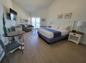 a bedroom with a bed and a couch and a table at Pointes North Beachfront Hotel - 2 Person Spa Tub Studios in Traverse City