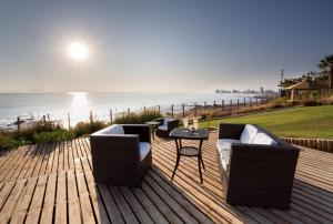 a deck with two chairs and a table and the ocean at NH Iquique Costa in Iquique