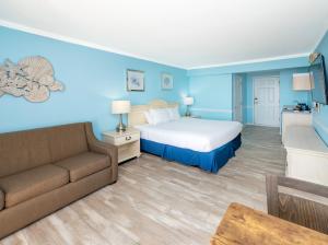 una habitación de hotel con una cama y un sofá en Drifting Sands Oceanfront Hotel, en Ship Bottom