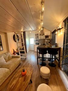 een woonkamer met een bank en een tafel bij Le Perchoir " Une nuit suspendu dans le temps" in Chessy