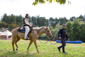 a man is riding a horse while a man is walking at Oshu - House - Vacation STAY 19753 in Hiraizumi