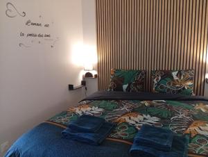 a bedroom with a bed with blue towels on it at L'Escapade in Villers-sur-le-Roule
