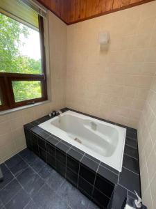 a bath tub in a bathroom with a window at The Lakehouse at Toyako - Vacation STAY 44256v in Tōya