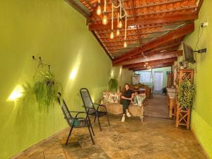 une femme assise sur un canapé dans un salon dans l'établissement Pousada Gaia Canastra, à São João Batista do Glória