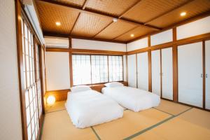due grandi letti bianchi in una stanza con finestre di Sakura Villa - Vacation STAY 54508v a Futo