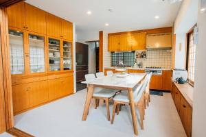 una cucina con mobili in legno, tavolo e sedie di Sakura Villa - Vacation STAY 54508v a Futo