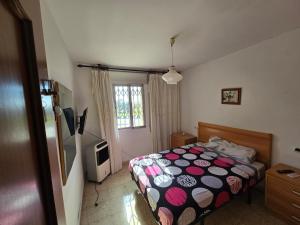 Un dormitorio con una cama y un televisor. en Bellavista, en La Línea de la Concepción