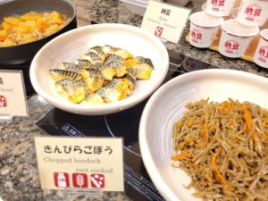 a counter with bowls of food and a bowl of noodles at Smile Hotel Osaka Tennoji - Vacation STAY 41030v in Osaka