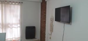 a flat screen tv on a wall next to a window at Departamento Urquiza2 in Alta Gracia