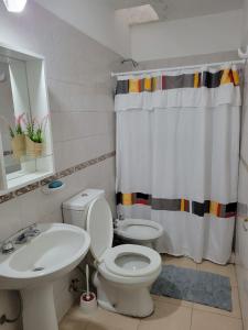 a bathroom with a white toilet and a sink at Departamento Urquiza2 in Alta Gracia