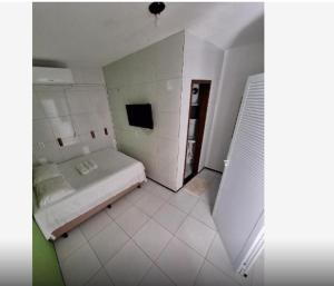 a white room with a bed and a bathroom at Ilha de Jeri in Jericoacoara
