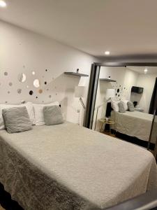 a bedroom with a bed and a wall with a mirror at Manu Double Room in London