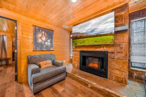 Una sala de estar con chimenea y una silla. en Mountain Views at Dolly's Castle Unit 4, en Sevierville