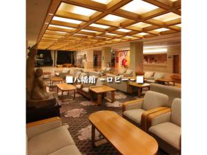 a waiting room with couches and tables and chairs at Yahatakan - Vacation STAY 99633v in Sado