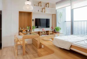 a bedroom with a bed and a desk and a television at Fuji Room Ở Space Ecopark in Kim Quan +7 photos