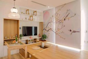 a living room with a table and a tv at Fuji Room Ở Space Ecopark in Kim Quan