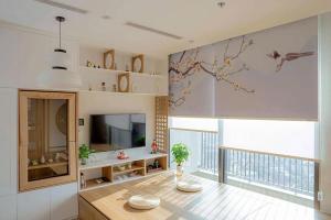 a living room with a table and a large window at Fuji Room Ở Space Ecopark in Kim Quan