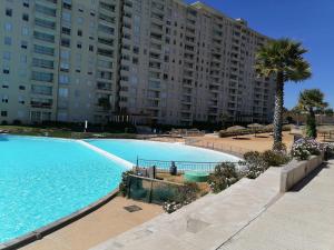 a large swimming pool in front of a large building at Vista velero in Algarrobo