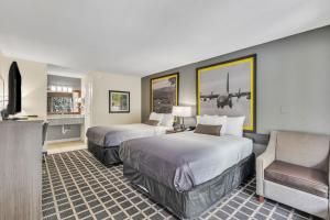 a hotel room with two beds and a couch at Super 8 by Wyndham Morganton in Morganton