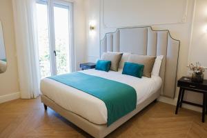 a bedroom with a large bed with blue pillows at SOFIA Suites & Rooms in Pompei