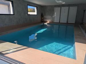 a large swimming pool with blue water in a house at Chez Gaëlle in Quiberon