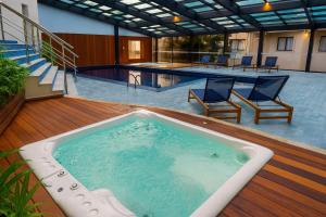 bañera de hidromasaje en una terraza junto a la piscina en Suite Confort - Resort em Gramado, en Gramado