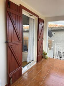 a room with two sliding doors and a balcony at Soleil éclatant in Sainte-Anne