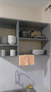 una cucina con mensola, stoviglie e lavandino di Abbey's bnb a Kikuyu