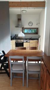 a kitchen with a wooden table and some chairs at Ferienwohnung am Römischen Haus in Weimar