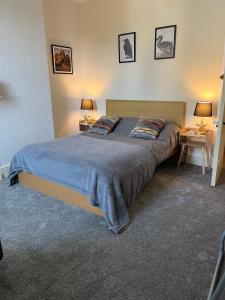 a bedroom with a large bed with two pillows at Large Mach Apartment at Pen Y Coed Hall in Dolgellau
