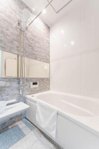ein weißes Badezimmer mit Badewanne und Waschbecken in der Unterkunft S-flat Kohama - Vacation STAY 20282 in Osaka