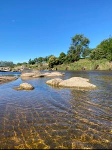 une rivière avec quelques rochers dans l'eau dans l'établissement La Serranita, à Panaholma