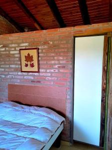 une chambre avec un mur de briques avec un lit et une porte dans l'établissement La Serranita, à Panaholma 3 autres photos