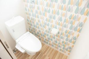 ein weißes WC im Bad mit Mosaikwand in der Unterkunft S-flat Kohama - Vacation STAY 20285 in Osaka + 7 Fotos