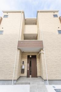 ein Gebäude mit einer Tür an der Seite in der Unterkunft S-flat Kohama - Vacation STAY 20285 in Osaka