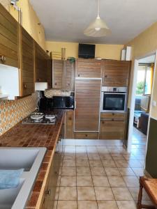 a kitchen with wooden cabinets and a counter top at Maison 3 chambres Le Mans, proche circuit in Le Mans