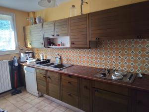 a kitchen with wooden cabinets and a counter top at Maison 3 chambres Le Mans, proche circuit in Le Mans
