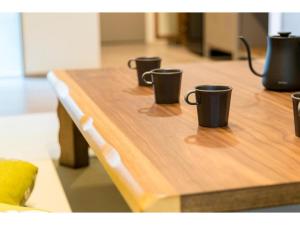 three coffee cups sitting on top of a wooden table at MUSUBI HOTEL KAMIGOFUKU-MACHI 1 - Vacation STAY 48031v in Hakata